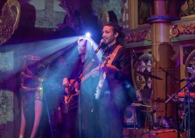 Un chanteur guitariste d'un groupe de musique chante lors d'une soirée d'entreprise