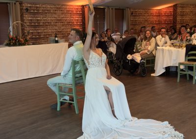 Les mariés, assis dos à dos sur des chaises, jouent au jeu lui ou elle animé par Many Events