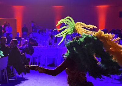 Une danseuse brésilienne décorée de plumes danse à une soirée d'entreprise par Many Events